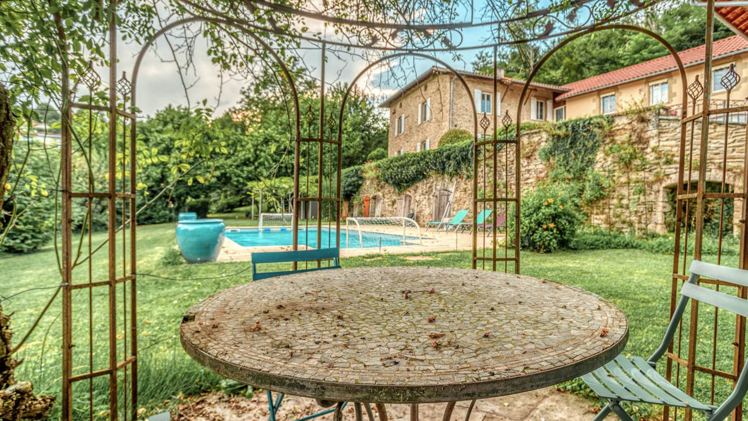 Vue immersive sur un jardin paysager avec piscine, captée à l’heure dorée pour sublimer l’atmosphère.