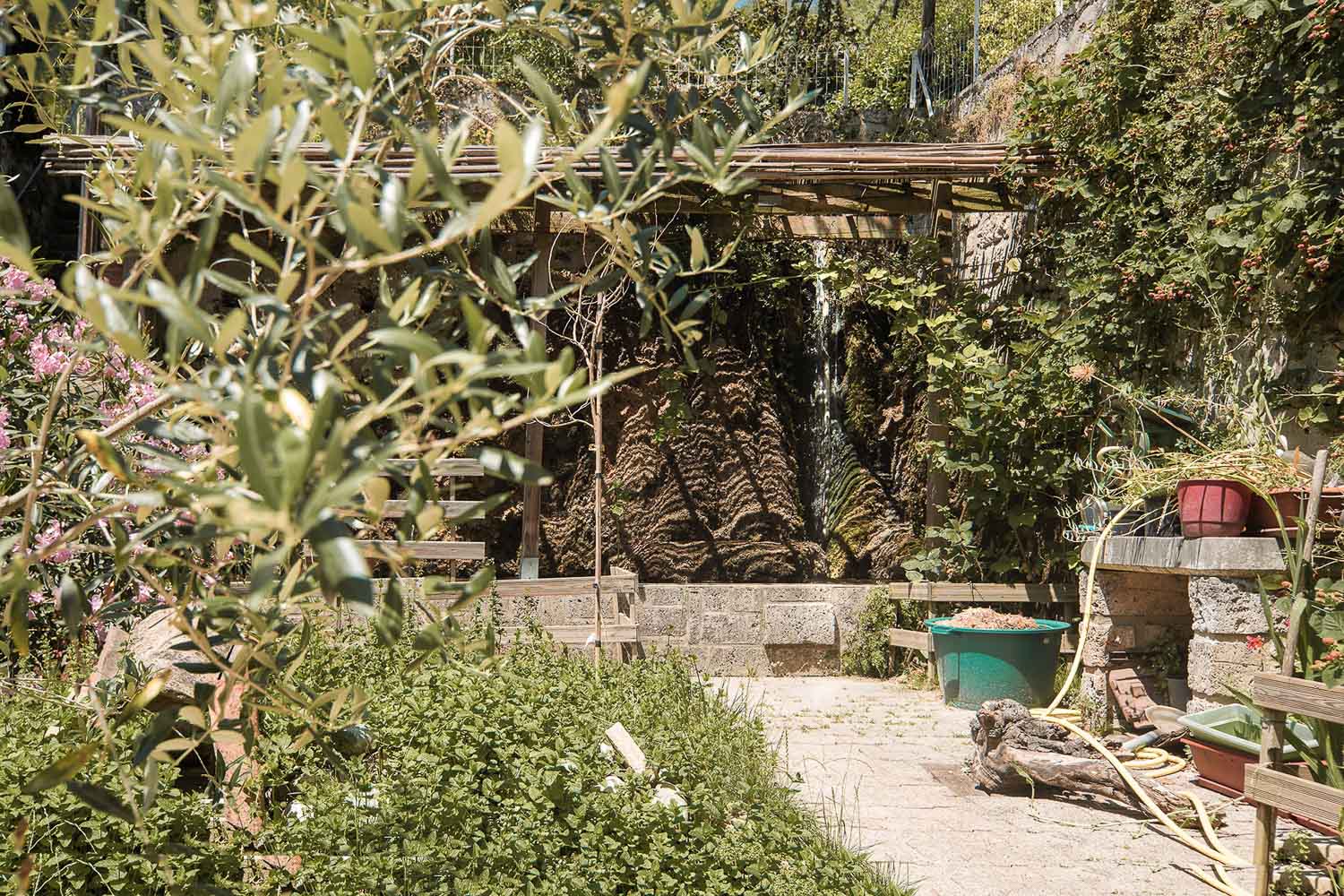 Focus sur un jardin secret et sa fontaine naturelle, mis en valeur par un jeu de flou artistique maîtrisé.