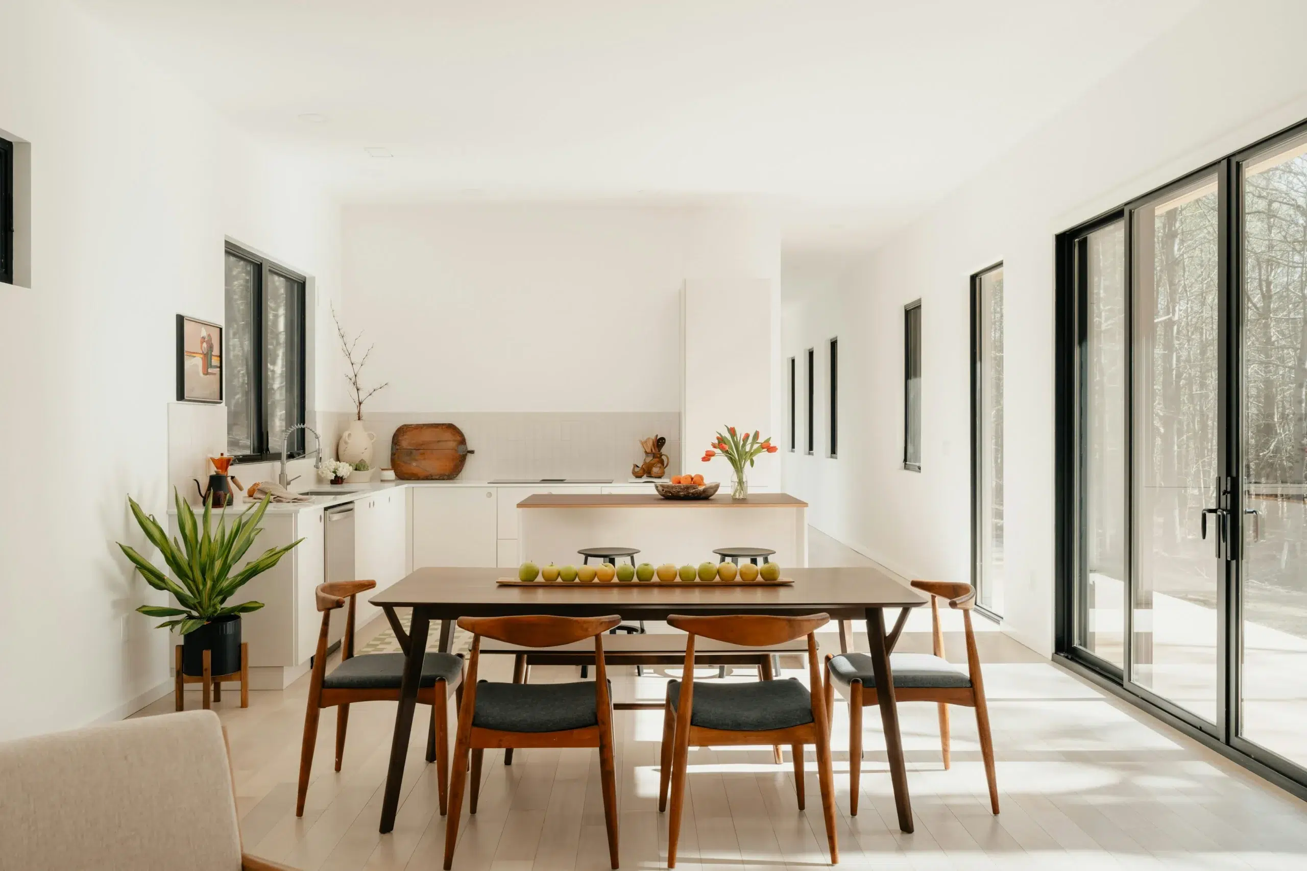 Intérieur lumineux et dégagé, salle à manger ouverte sur une cuisine, sans présence humaine dans le cadre. Photo : Clay Banks.